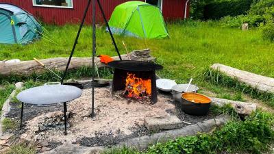 bål ved spejderhytten med telte i baggrunden